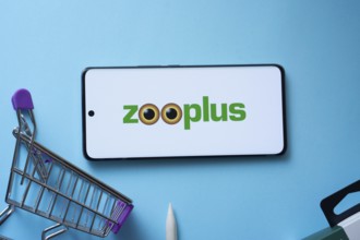 Dhaka, Bangladesh- 03 July 2025: Smartphone displaying zooplus logo with shopping cart on a blue