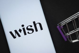 Dhaka, Bangladesh- 03 July 2025: A smartphone displaying the Wish logo next to a miniature shopping