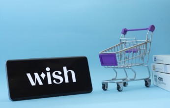 Dhaka, Bangladesh- 03 July 2025: Smartphone with Wish logo next to a small shopping cart and boxes
