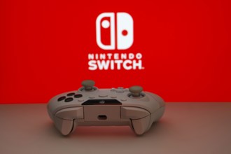 Dhaka, Bangladesh- 15 July 2025: Smartphone with nintendo switch logo, game controller, and earbuds