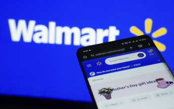 Dhaka, Bangladesh- 03 July 2025: Smartphone displaying Walmart web interface against Walmart logo