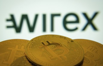 Dhaka, Bangladesh- 18 Sep 2025: Close-up of Bitcoin coins with thex wirex logo visible on a screen