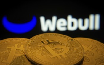 Dhaka, Bangladesh- 27 July 2025: Close-up of Bitcoin coins with the webull logo visible on a screen