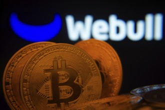 Dhaka, Bangladesh- 03 Sep 2025: Close-up of Bitcoin coins with the webull logo visible on a screen