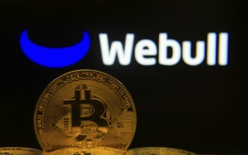 Dhaka, Bangladesh- 04 April 2025: Close-up of Bitcoin coins with the webull logo visible on a