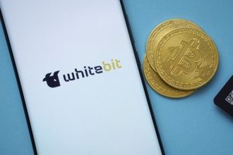 Dhaka, Bangladesh- 03 Sep 2025: Whitebit logo on smartphone screen near Bitcoin coin and QR code on