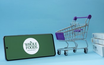 Dhaka, Bangladesh- 03 July 2025: Smartphone with Whole Foods Market logo next to a small shopping