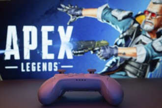 Dhaka, Bangladesh- 19 Sep 2025: A close-up of a white gamepad with the Apex Legends seen on screen