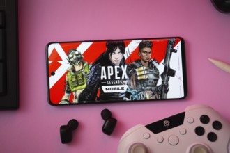 Dhaka, Bangladesh- 19 Sep 2025: A close-up of a white gamepad with the Apex Legends mobile seen on