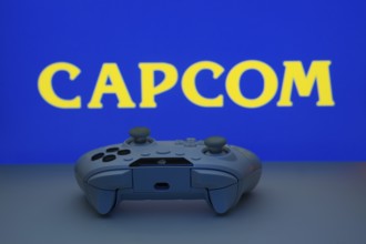 Dhaka, Bangladesh- 19 Sep 2025: A close-up of a white gamepad with the Capcom seen on screen in the