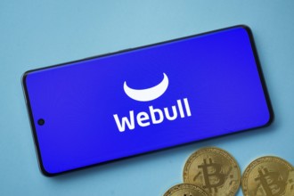 Dhaka, Bangladesh- 03 Sep 2025: webull logo on smartphone screen near Bitcoin coin and QR code on