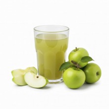 A refreshing glass of apple juice is presented alongside fresh green apples, some whole and others