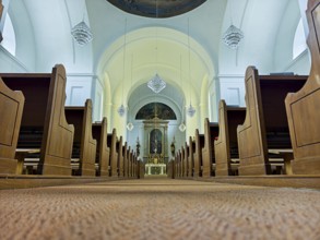 Church interior with view of the altar, wooden benches and quiet atmosphere, Kammersdorf Hollabrunn