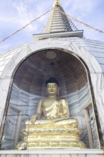 Golden Buddha statue in a stupa, meditating, surrounded by glass protection, Stupa am Wagram