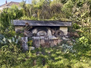 An old stone oven embedded in nature with surrounding plants and a rustic atmosphere, Weinviertel