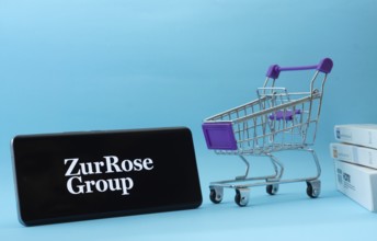 Dhaka, Bangladesh- 03 July 2025: Smartphone with Zur Rose Group logo next to a small shopping cart