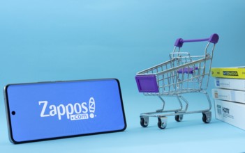 Dhaka, Bangladesh- 03 July 2025: Smartphone with Zappos logo next to a small shopping cart and