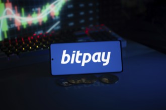 Bitpay logo presented with coins and glowing market graphs, reflecting digital commerce