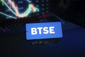BTSE logo on smartphone with coins and stock chart, suggesting finance and digital market