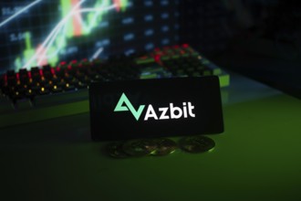 Azbit logo on phone, displayed with coins and stock chart, emphasizing finance and technology
