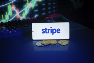 Phone with Stripe logo beside coins and market chart, implying financial transactions