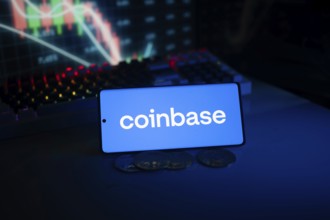 Coinbase logo shown in front of trading charts and coins with a blue-lit background
