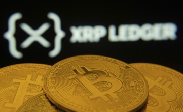 Dhaka, Bangladesh- 27 July 2025: Close-up of Bitcoin coins with the XRP Ledger logo visible on a