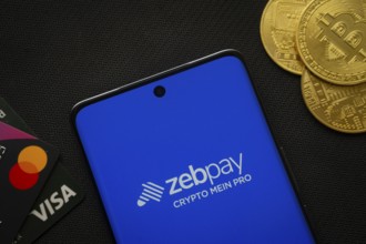 Dhaka, Bangladesh- 15 June 2025: Smartphone displaying zebpay logo surrounded by Bitcoin coins and