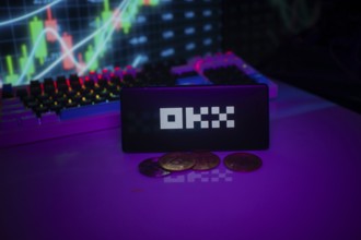OKX logo displayed amidst purple hue with coins and trading graphs visible behind