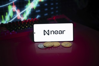 Near protocol logo on a lit screen with coins and trading graphs in the background