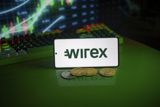 Phone displays Wirex logo with crypto coins and trading screen in background