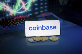 Coinbase logo on smartphone with coins, blue neon lights, and trading charts in background