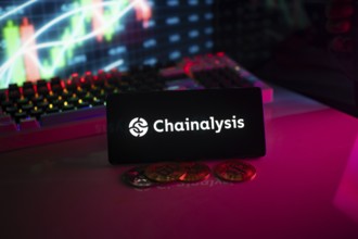 Chainalysis logo displayed in a dark atmosphere with coins and a colorful chart