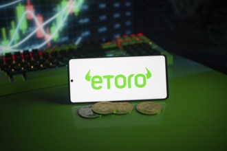 EToro logo on green screen with coins and trading graphs in the background
