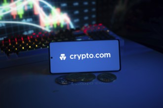 Crypto.com logo with coins and dynamic market graph in blue-lit setting