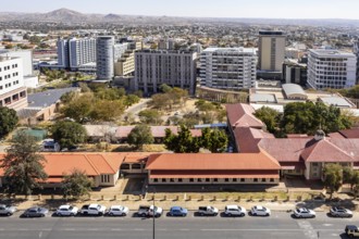 Modern downtown Windhoek, Namibia, with tall contemporary buildings, wide streets, moving cars, and