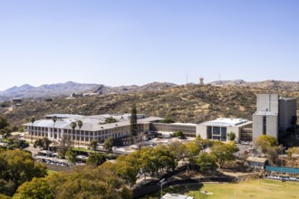 Modern downtown Windhoek, Namibia, with tall contemporary buildings, wide streets, moving cars, and