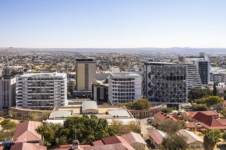 Modern downtown Windhoek, Namibia, with tall contemporary buildings, wide streets, moving cars, and