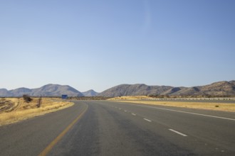 Scenic view of the open road between Windhoek and Outjo, surrounded by dry grasslands and distant