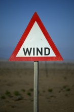 Caution wind sign on a road near Oranjemund, diamond restricted area, Karas region, Namibia