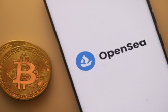 Bitcoin coin beside a smartphone showing the OpenSea logo on a light background