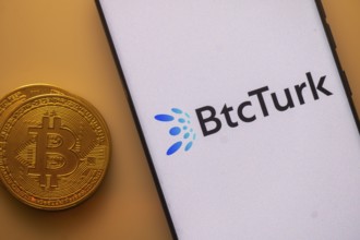 Bitcoin beside a smartphone with BtcTurk logo on a white background