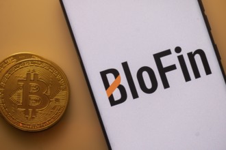 Bitcoin placed beside a smartphone with BloFin logo on a white background