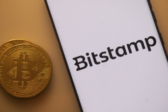 Bitstamp logo on white screen beside Bitcoin, indicating crypto trading platform
