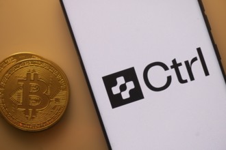 Bitcoin and Ctrl logo displayed on a smartphone with orange ambient lighting