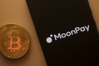 Bitcoin coin beside a smartphone displaying the MoonPay logo on a dark background