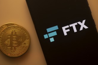 Bitcoin coin next to a smartphone showing the FTX logo on a dark screen