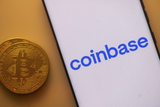 Coinbase app displayed on a smartphone beside a Bitcoin coin image