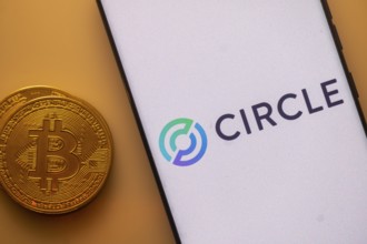 Bitcoin coin beside a white phone screen displaying the Circle logo