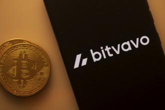 Bitvavo logo on a smartphone alongside a Bitcoin coin